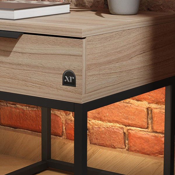 Wooden desk with black metal legs against a brick wall.