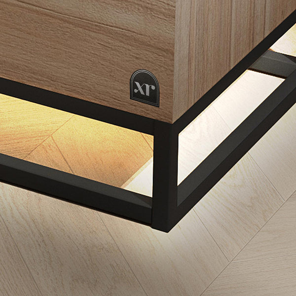 Wooden furniture corner with black frame and XR Living logo on a light wood floor.