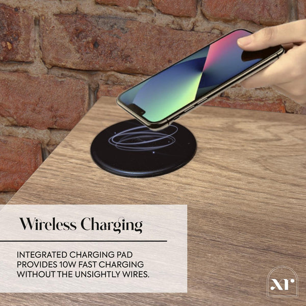 Hand placing a smartphone on a wireless charging pad with a brick wall background