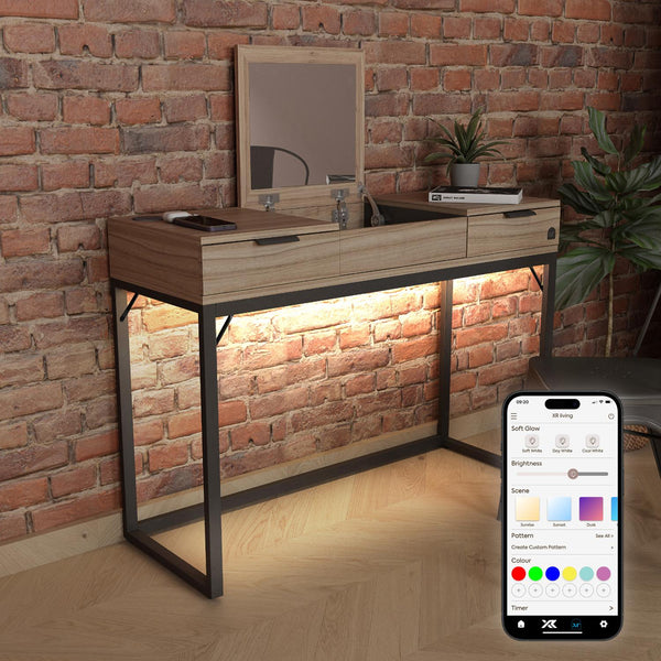 Wooden vanity table with mirror against a brick wall, illuminated by smart lighting control app on phone.