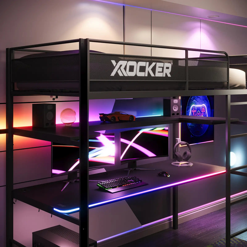 Gaming desk with X rocker branding, multiple monitors, and RGB lighting in a modern room.