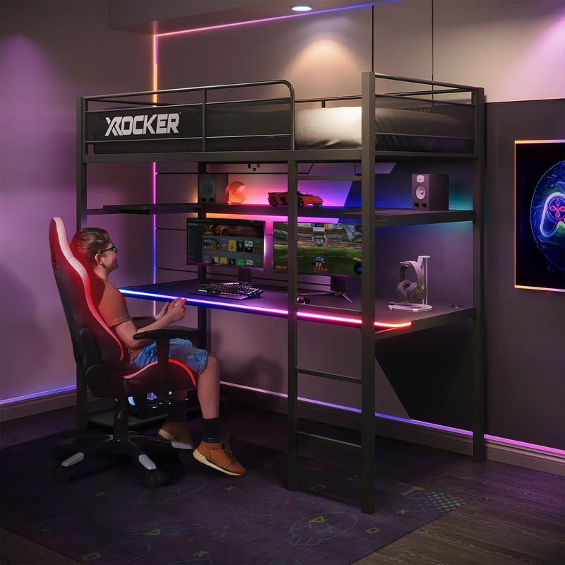 Gaming setup with a desk, chair, and computer equipment in a room with colorful lighting.