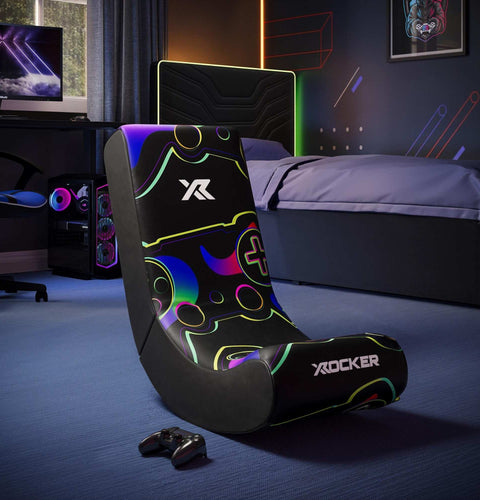 Gaming chair with colorful design in a room setup with a TV and gaming accessories.