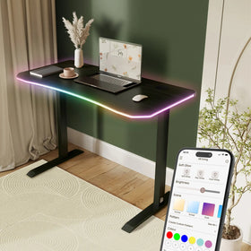 Modern desk with RGB lighting and a laptop, accompanied by a smartphone displaying lighting app.
