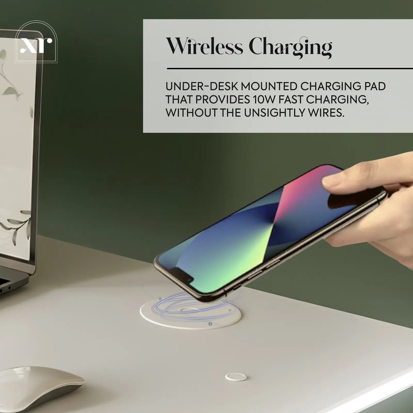 Hand placing a smartphone on a wireless charging pad with text about the desk product's features.