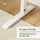 White metal stand on a wooden floor with text about premium materials and load capacity.