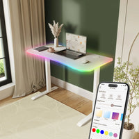 Modern desk with RGB lighting controlled by a smartphone app in a home office setting.
