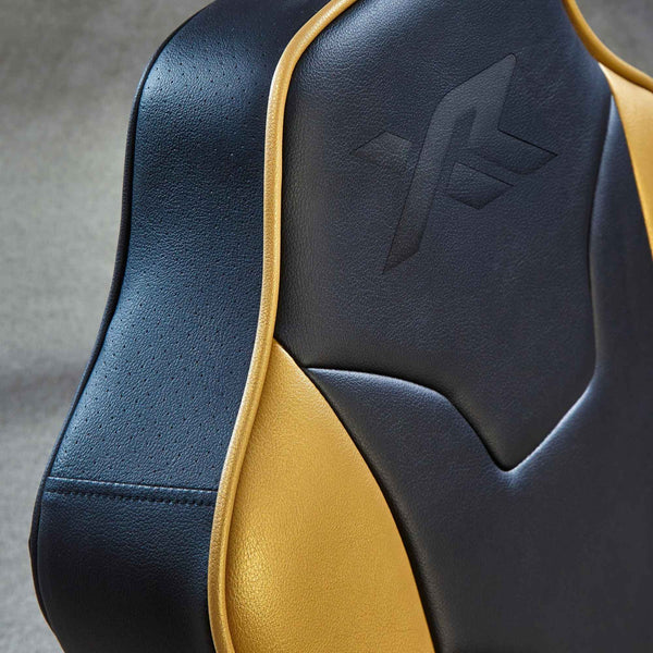 Close-up of a black and gold leather seat with a logo on a gray background