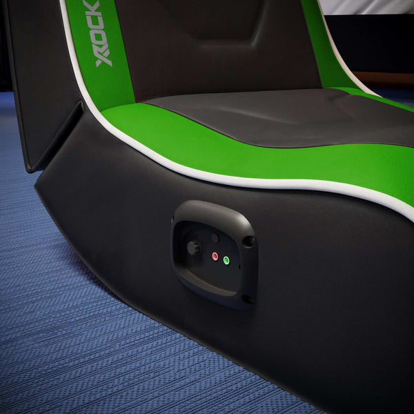 Close-up of a gaming chair with green and black design on a blue carpet.