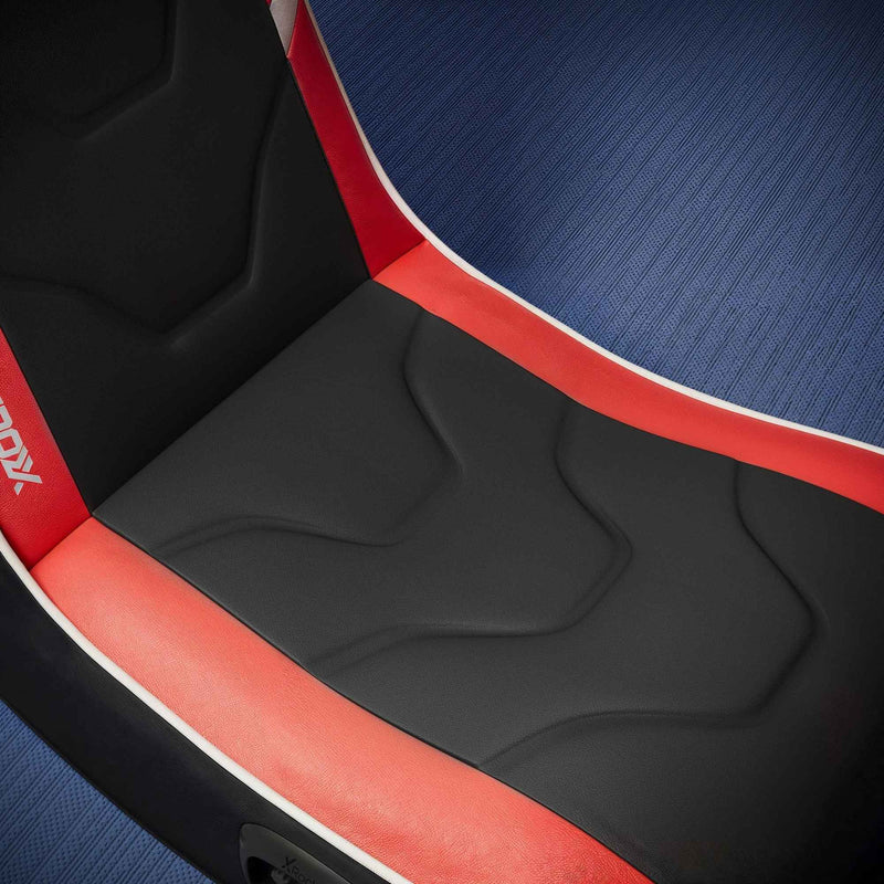 Close-up of a gaming chair seat with red and black design on a blue textured background