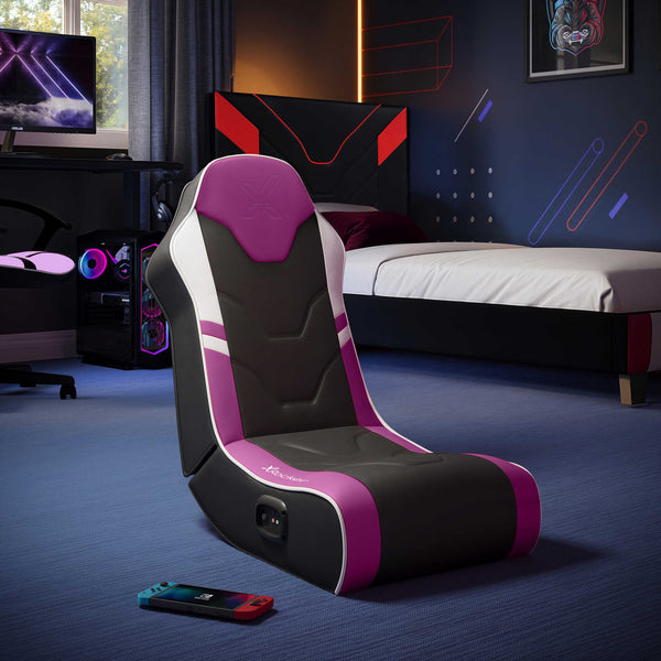 Gaming chair with purple and black design in a room with gaming setup.